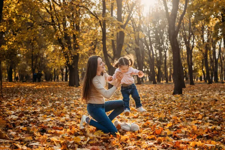 A woman smiles while holding a toddler